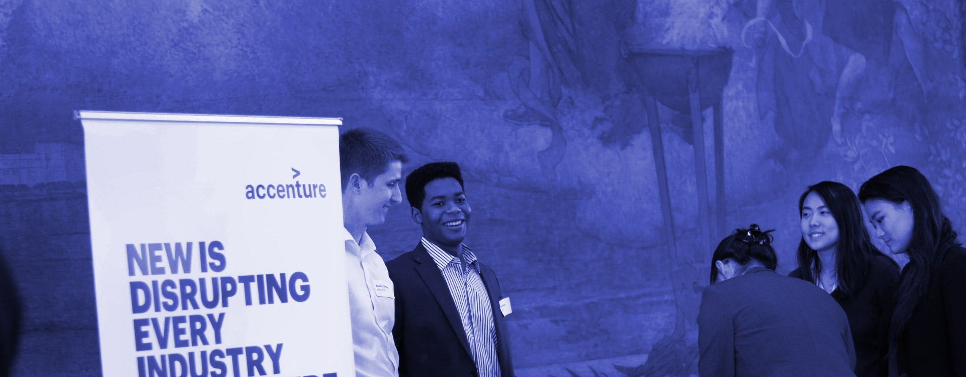People at the Accenture employer booth talk to students at a UPOP event