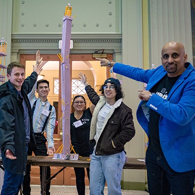 UPOP mentor and students displaying a completed tower they constructed