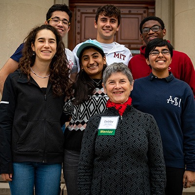 UPOP mentor with six students outside on the steps of MIT campus